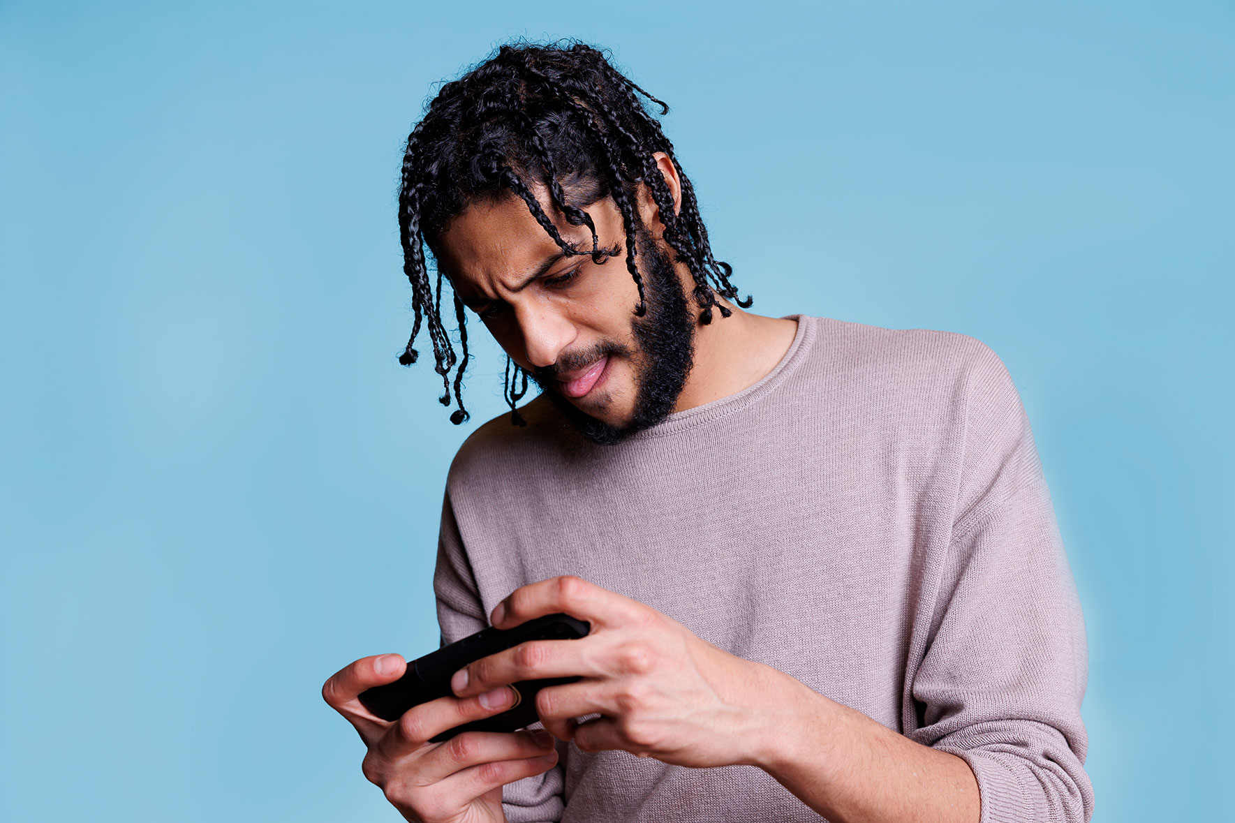 focused-arab-man-holding-mobile-phone-playing-online-game focused-arab-man-holding-mobile-phone-playing-online-game